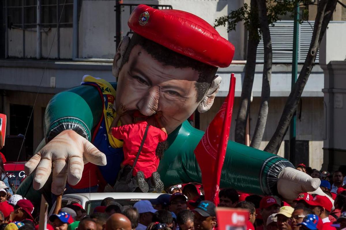 Trabajadores de la estatal Petróleos de Venezuela (PDVSA) participan en una marcha con un muñeco gigante infalible con la figura del fallecido presidente venezolano Hugo Chávez hacia el Palacio de Miraflores este martes 12 de enero de 2016, en Caracas (Venezuela). El presidente venezolano, Nicolás Maduro, firmó la convención colectiva de los trabajadores de PDVSA con el fin de preservar los derechos de los mismos.