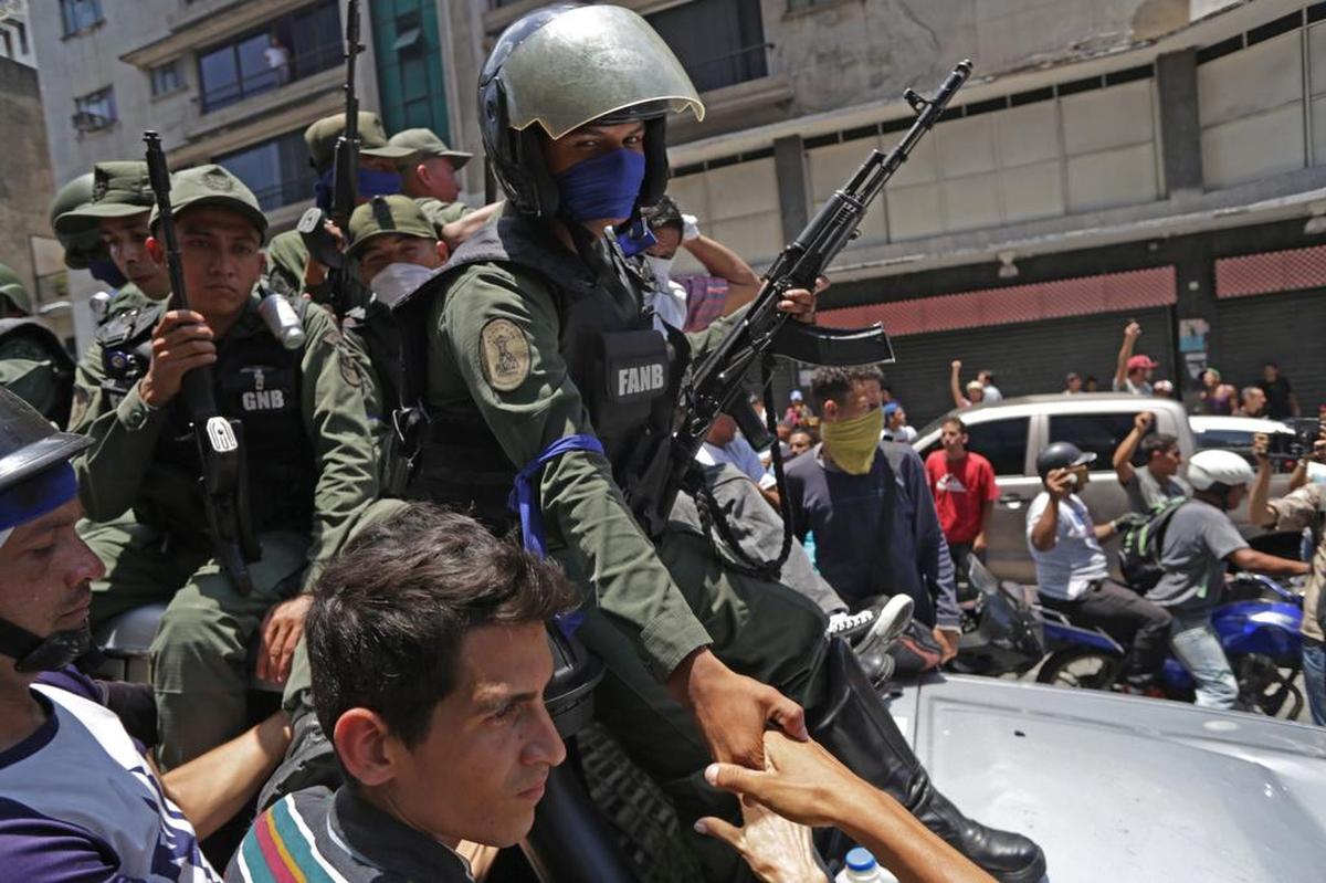 Members of the Bolivarian National Guard who joined Venezuelan opposition leader and interim President Juan Guaidó in his campaign to oust leader Nicolás Maduro, are greeted by opposition supporters in Caracas on April 30, 2019. Guaidó, accused by the government of attempting a “coup” Tuesday, said there was “no turning back” in his attempt to oust Maduro from power.