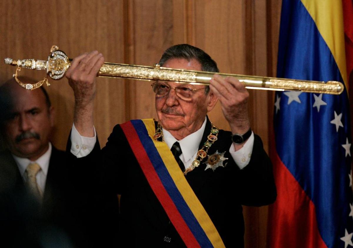 El gobernante de Cuba, Raúl Castro, sostiene una réplica de la espada de Simón Bolívar que le dio el ex presidente venezolano, Hugo Chávez, en el palacio presidencial de Miraflores en Caracas, el sábado 13 de diciembre de 2008.