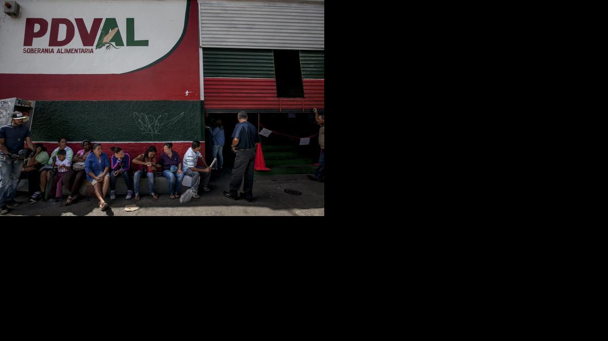 
Un grupo de personas aguarda en la entrada de un supermercado Productora y Distribuidora Venezolana de Alimentos (PDVAL) el viernes 9 de enero del 2015, en la ciudad de Caracas (Venezuela). 
