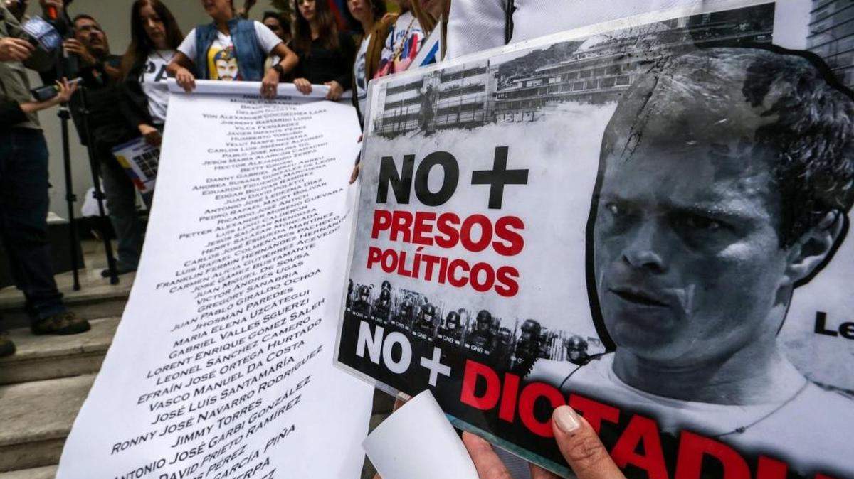 La esposa del dirigente opositor Leopoldo López, Lilian Tintori (c-arriba), despliega una pancarta con una lista de los más de 100 presos políticos el martes 7 de marzo de 2017, en Caracas, Venezuela. Tintori, acompañada de familiares de presos políticos, entregó un documento a favor de la aplicación de la Carta Democrática de la Organización de Estados Americanos (OEA), en Venezuela, ante la presidencia de la Asamblea Nacional.