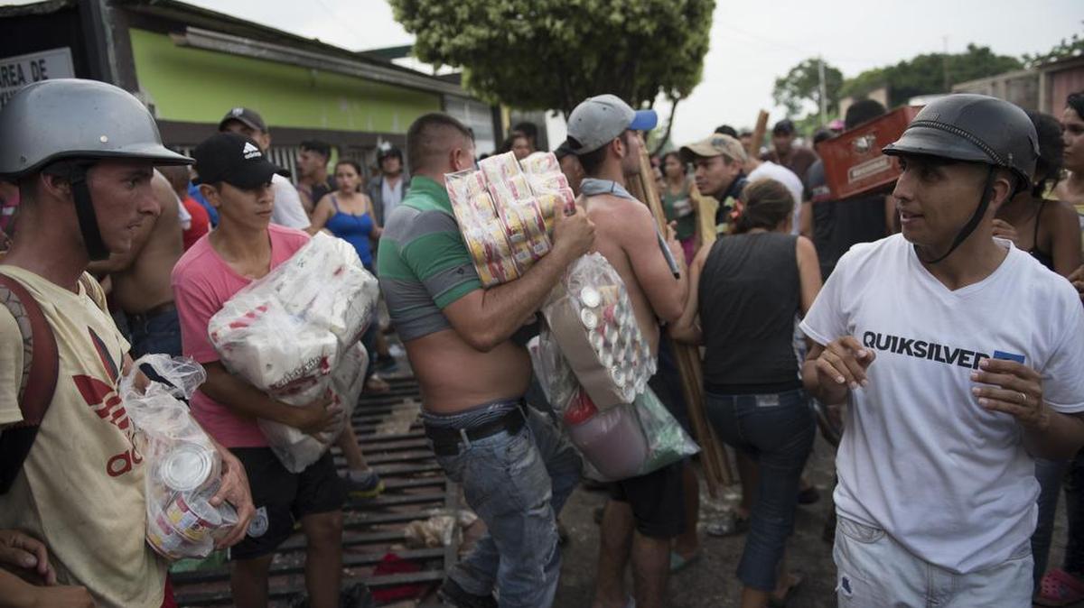 Decenas de personas saquean un almacén de comida el sábado en la población de La Fría, estado Táchira, Venezuela.
