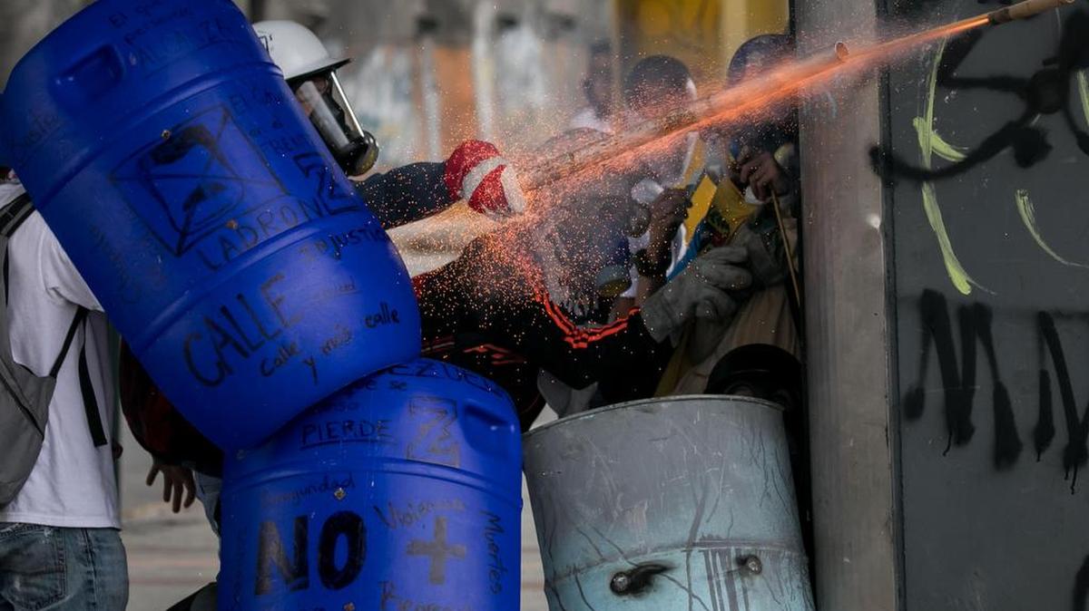Venezolanos opositores se enfrentan a la Policía Nacional Bolivariana (PNB) durante una manifestación el miércoles 7 de junio de 2017, en Caracas (Venezuela).
