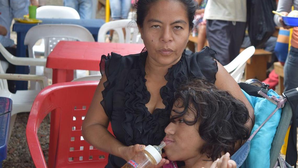 Yasmira Gordillo, de 46 años, alimenta a su hija María, de 19 años, en Cúcuta, Colombia. La mujer hizo un viaje de 14 horas en autobús desde Valencia, Venezuela, con su hija para conseguir los medicamentos contra las convulsiones que necesita la joven, quien padece de parálisis cerebral.