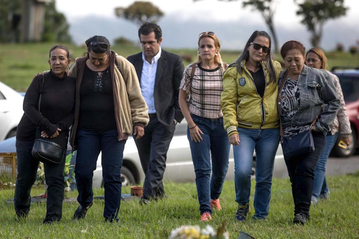 Familiares de Óscar Pérez y Alfredo Romero (centro), el presidente del Foro Penal Venezolano durante el entierro del policía venezolano este domingo 21 de enero de 2018, en el Cementerio del Este de Caracas (Venezuela).