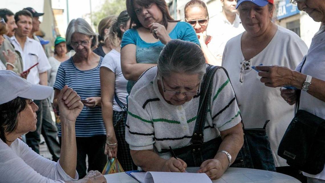 Opositores al gobierno de Nicolás Maduro firman planillas el 12 de octubre de 2016, para ofrecerse como voluntarios en la recolección de firmas para el revocatorio, en Caracas, Venezuela.