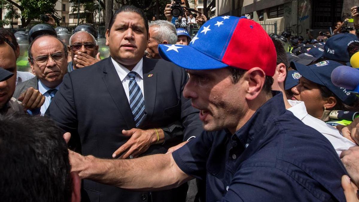 El gobernador del céntrico estado Miranda y dos veces candidato presidencial, Henrique Capriles (d), habla con rector principal del Poder Electoral, Luis Emilio Rondón, en una manifestación el 23 de enero de 2017, en la ciudad de Caracas (Venezuela).