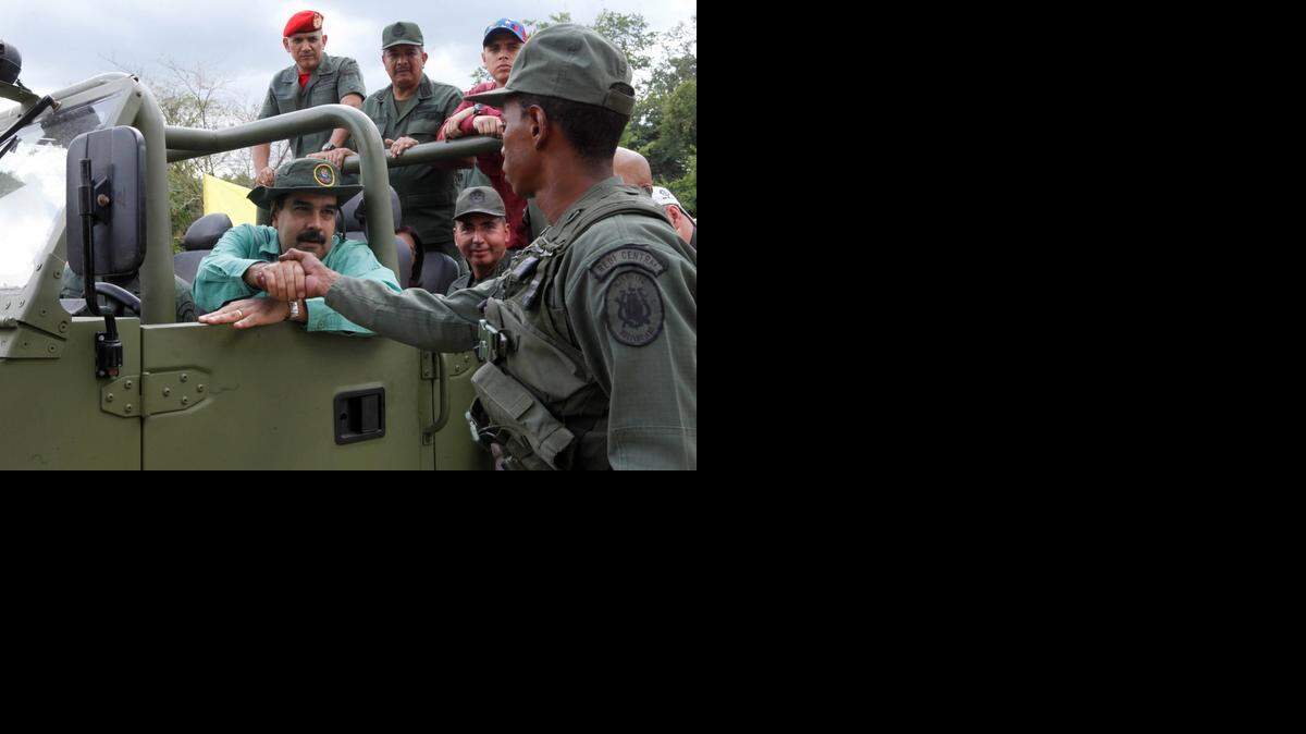 
Nicolas Maduro, sentado al timón de un vehículo militar, saluda a un soldado durante una visita a una instalación militar en Caracas el pasado mes de octubre.
