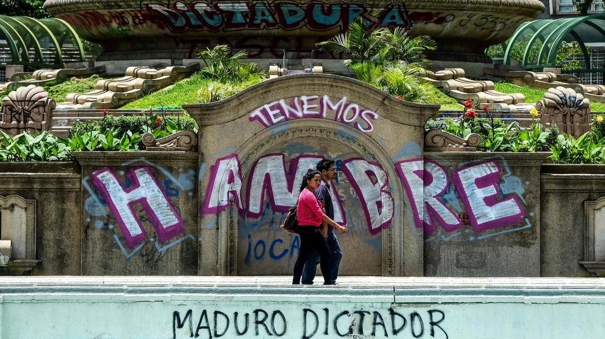 Una pareja camina por una calle de Caracas el 8 de agosto de 2017.