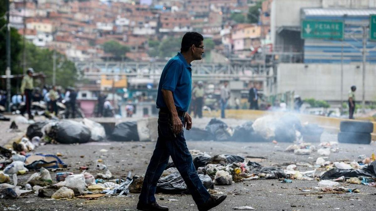 Un hombre cruza una calle bloqueada por las protestas en Venezuela, el 2 de mayo.