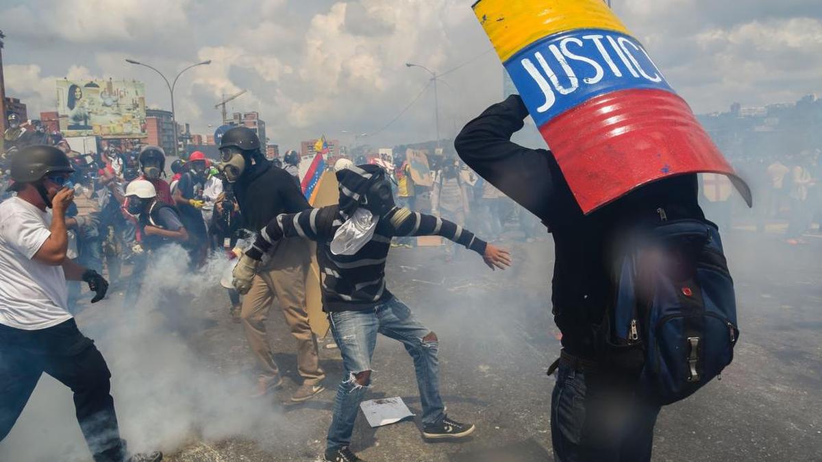 Manifestantes opositores se protegen con escudos de fabricación casera durante un enfrentamiento con agentes policiales, como parte de las protestas antigubernamentales el miércoles 10 de mayo de 2017, en Caracas.