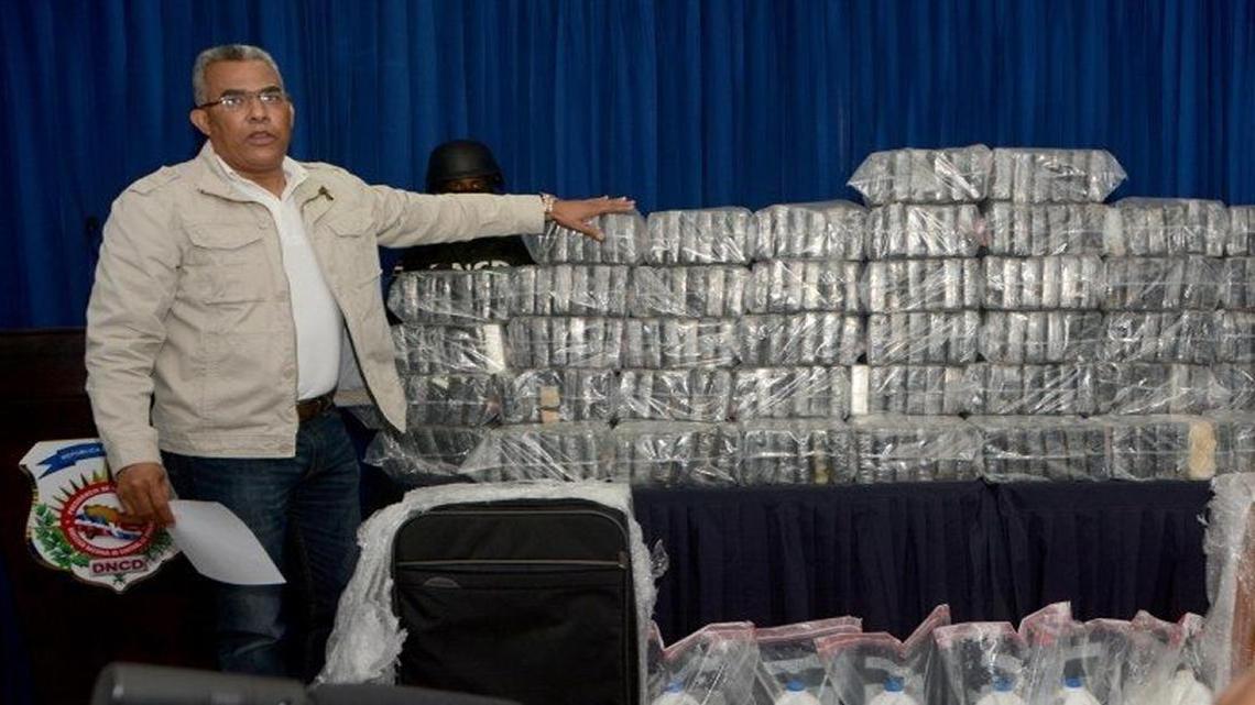 Un funcionario dominicano muestra el alijo de 349 paquetes de cocaína, hallado en tres maletas y dos bultos transportados desde Venezuela a República Dominicana en un avión del tipo Cessna, modelo C404, matrícula YV2708.