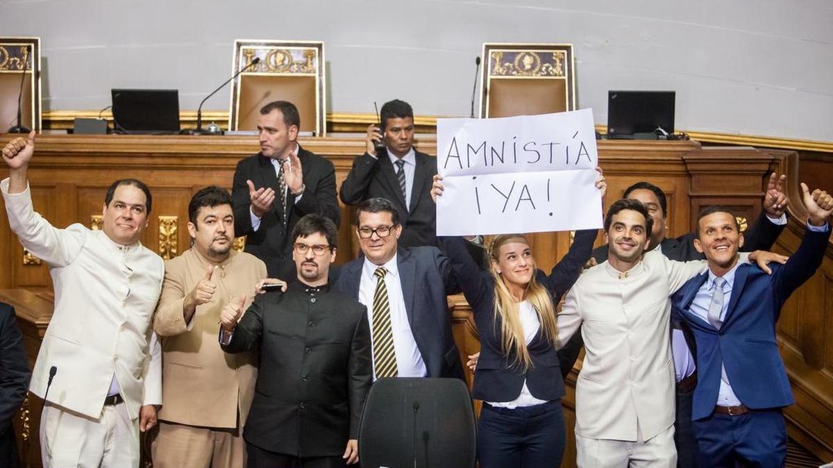 Lilian Tintori, esposa del líder opositor detenido Leopoldo López, acompañada de diputados de la Mesa de Unidad Democrática, sostiene un cartel pidiendo una amnistía durante la instalación de la Asamblea Nacional de Venezuela hoy, martes 5 de enero de 2016, en Caracas (Venezuela). Los diputados elegidos toman posesión hoy de sus cargos con lo que se pondrá fin a la hegemonía parlamentaria chavista de los últimos 17 años, después de que la oposición obtuviese el 6 de diciembre una mayoría de 112 diputados frente a los 55 conseguidos por el oficialismo.