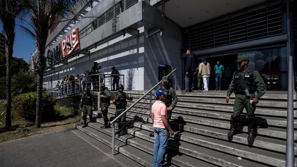 Personas hacen fila en la entrada de un supermercado en la ciudad de Caracas, el 6 de enero del 2018. Inspectores del gobierno venezolano ordenaron a unas 26 cadenas de supermercados en Venezuela bajar los precios de distintos productos.