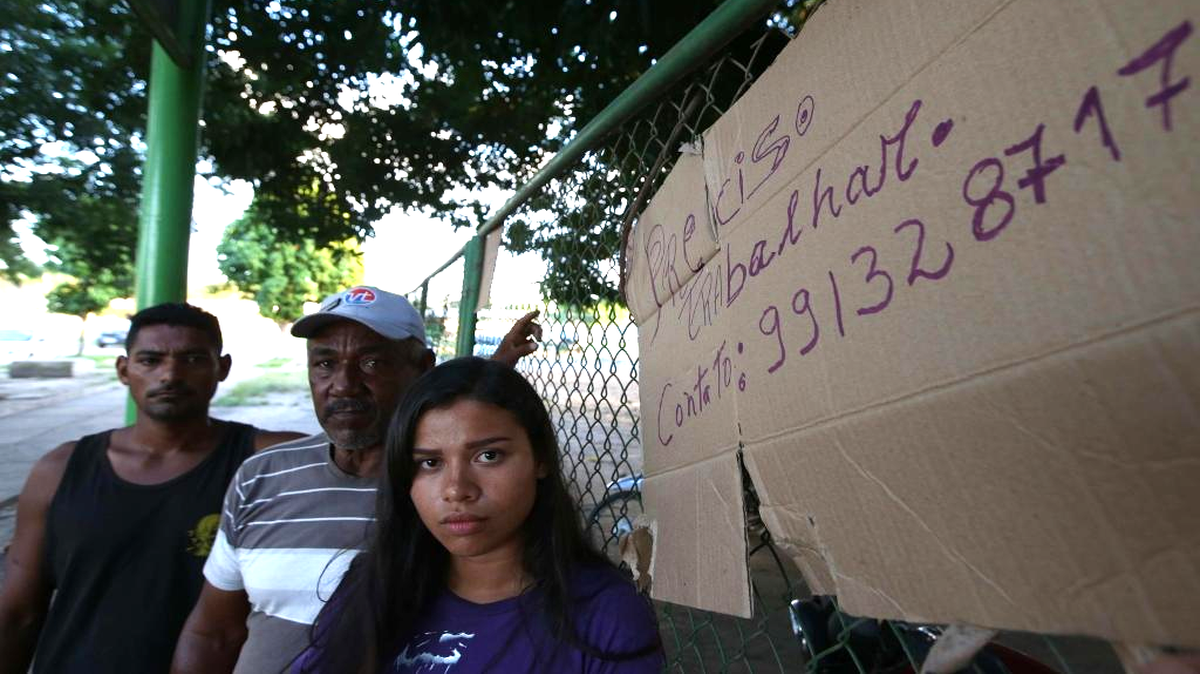 Los venezolanos Juan Carlos Álvarez (i), Víctor Soto (c) y Sairelis Ríos (d) buscan trabajo el jueves, 20 de octubre de 2016, en Boa Vista, estado de Roraima (Brasil). Es venezolana, tiene 20 años, quiere ser traductora y hoy, en una hamaca colgada en un árbol que ha convertido en su casa en la ciudad brasileña de Boa Vista, mece unos sueños que, según aseguró, no serán truncados por "el fracaso de una revolución". "No estoy aquí por política. Lo que me trajo aquí fue el fracaso de unas políticas", dijo a Efe Sairelis Ríos, quien junto a su madre Keila y una decena de venezolanos vive en plena calle, frente a la terminal de autobuses de Boa Vista, una ciudad que en los últimos meses ha recibido unos 2.500 emigrantes de ese país vecino.