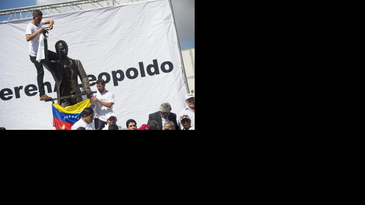 Un grupo de personas participa, el miércoles 18 de febrero de 2015, en una manifestación convocada por Lilian Tintori, esposa del líder opositor Leopoldo Lopez, en el lugar donde hace un año su esposo se entregó a la justicia venezolana, en Caracas (Venezuela). 
