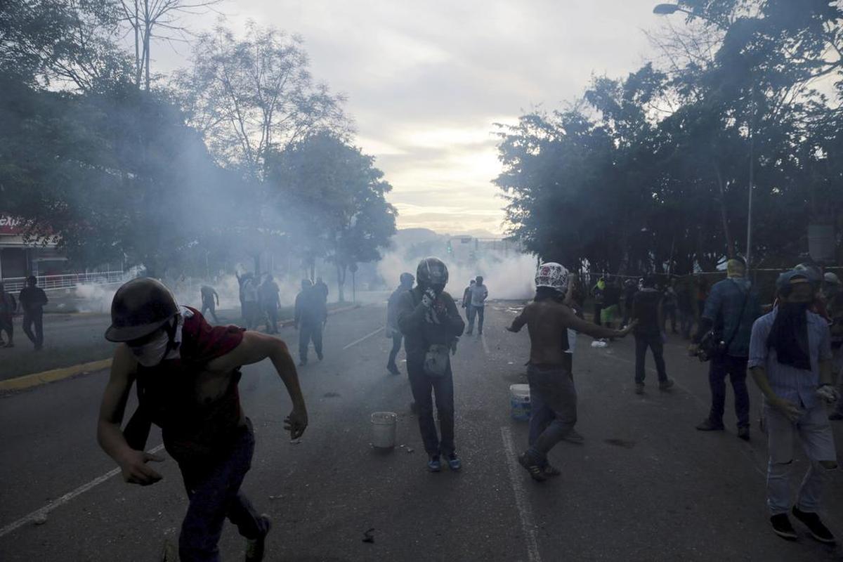 Manifestantes se refugian durante los enfrentamientos con la Guardia Nacional Bolivariana, en el municipio de El Hatillo, en las afueras de Caracas, Venezuela, el martes 2 de mayo de 2017.