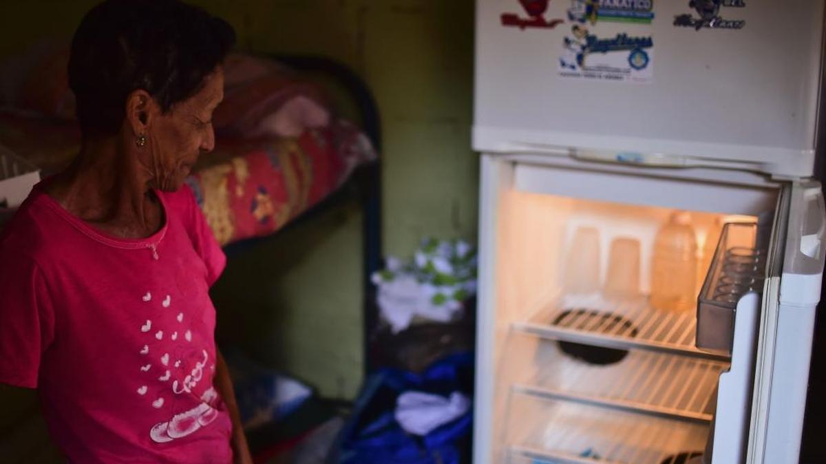 Mayra de Ramos, una vecina de Gramoven que pasó todo un día haciendo fila para comprar comida, muestra su nevera vacía.