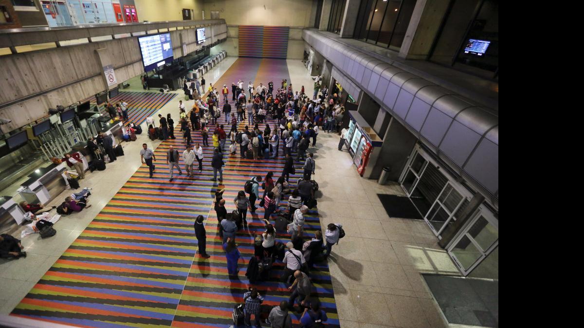 
Pasajeros hacen fila frente a los mostradores de una aerolínea para abordar sus vuelos en el aeropuerto Simón Bolívar de Maiquetía en el 2013.
