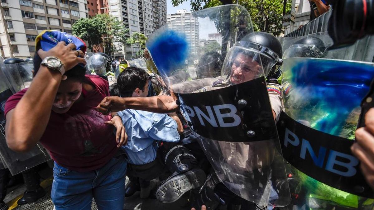 Opositores venezolanos se pelean con agentes de la policía antidisturbios durante una protesta contra el gobierno de Nicolás Maduro en Caracas el 4 de abril de 2017.