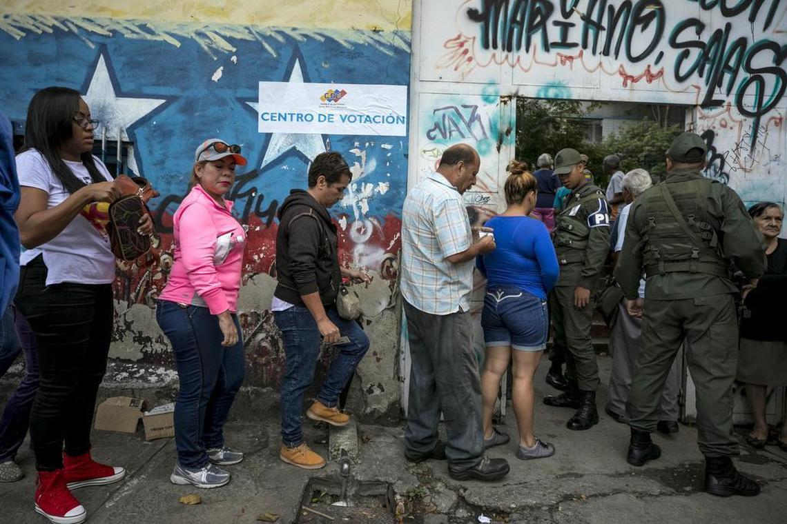 Varias personas asisten a un centro de votación el 15 de octubre de 2017, en Caracas (Venezuela).