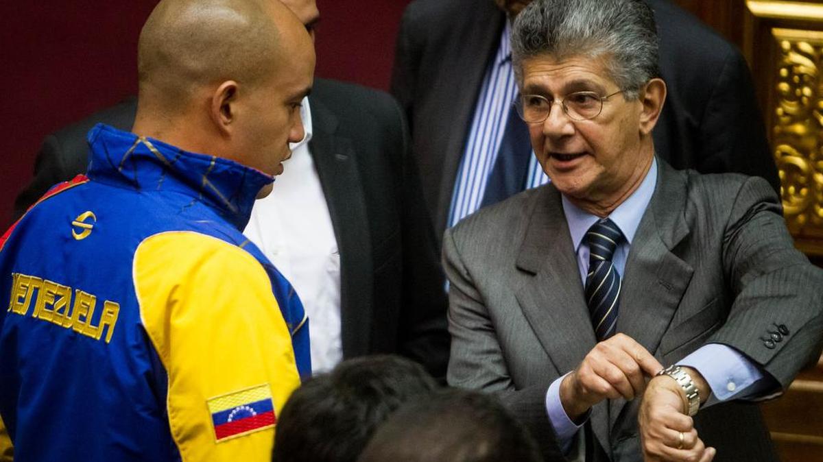 El presidente de la Asamblea Nacional de Venezuela, Henry Ramos Allup (der.), habla con el diputado del Partido Socialista Unido de Venezuela Héctor Rodríguez en el hemiciclo de sesiones del palacio legislativo.