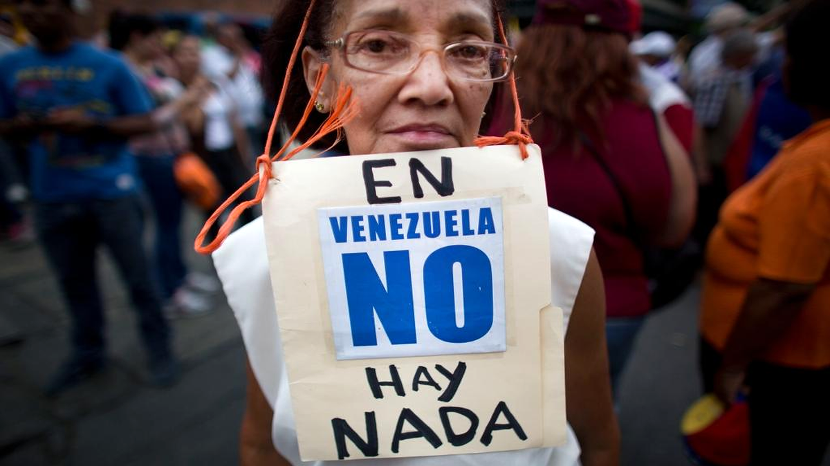 Beatriz Silva, de 74 años, lleva un letrero que condena la escasez en Venezuela, en una protesta en la capital, en agosto.