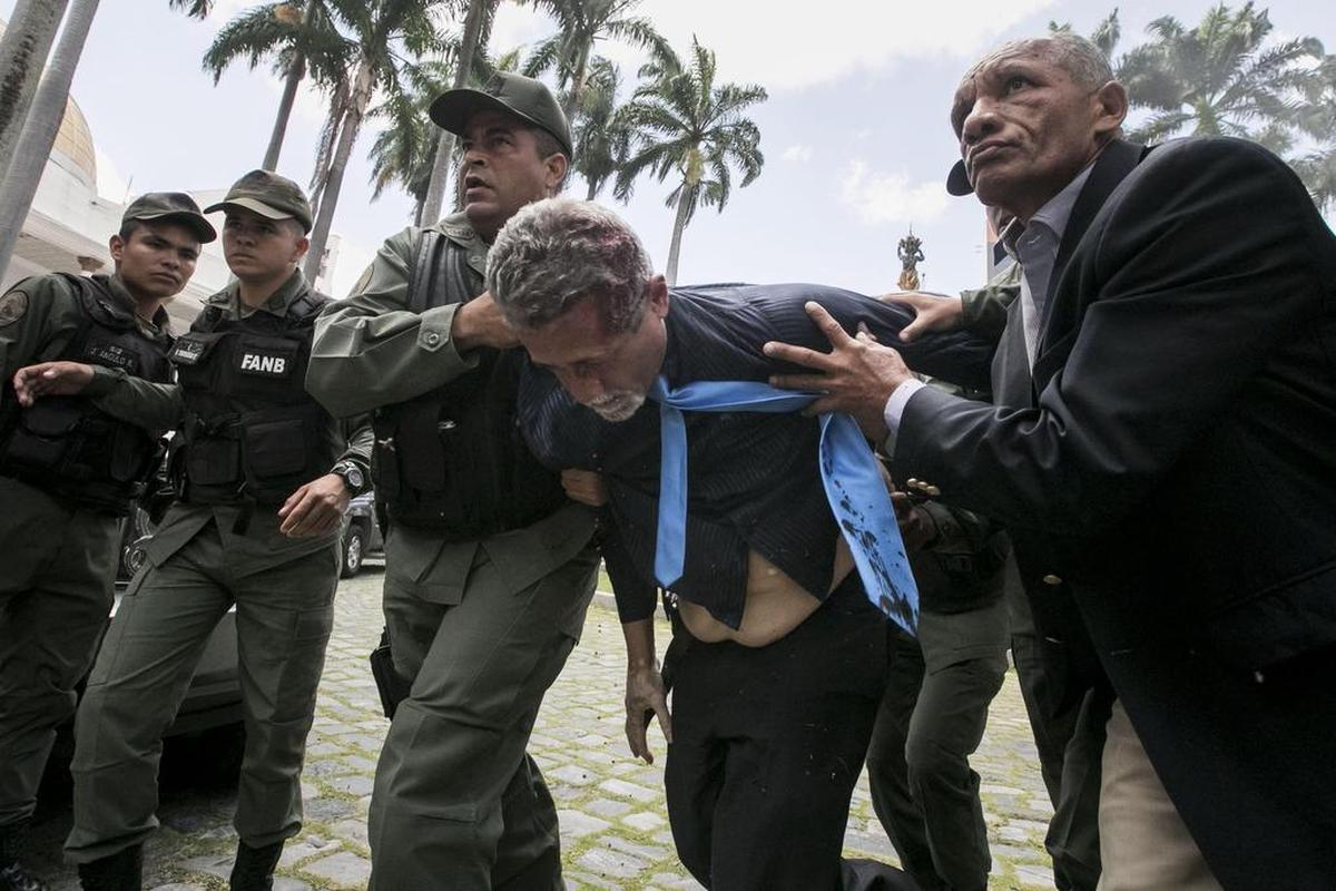 El diputado Américo De Grazia es auxiliado por militares tras ser golpeado por manifestantes que ingresaron a la Asamblea Nacional el miércoles 5 de julio de 2017, en Caracas (Venezuela).