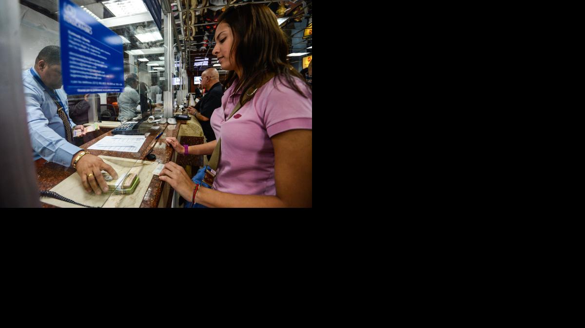 
Una cliente recibe dinero en una oficina de cambio de divisas en Caracas el 19 de febrero de 2015. 
