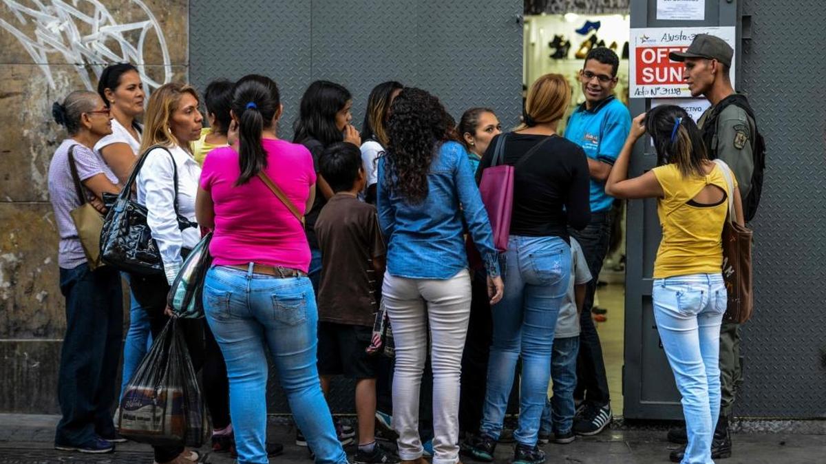 La gente espera su turno para entrar a una zapatería a la que el gobierno venezolano ha obligado a vender con descuento del 30%.