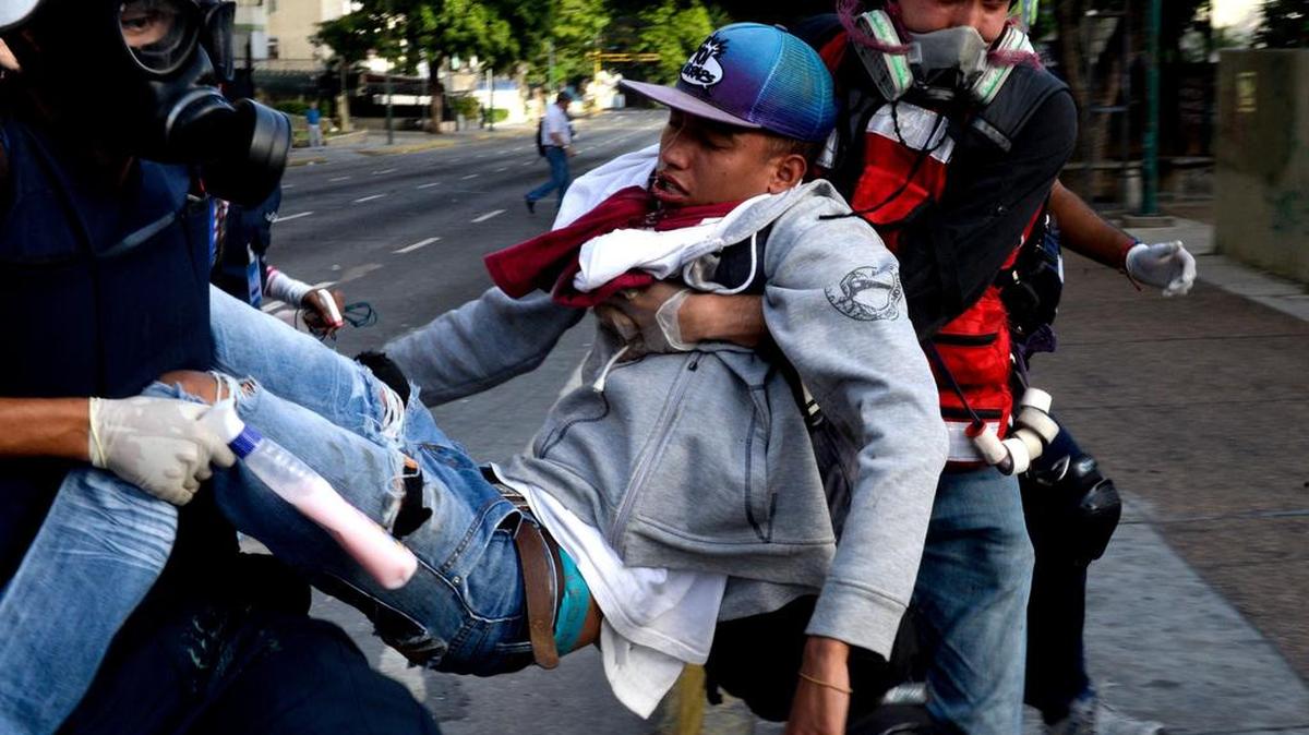 Un joven herido es transportado por varios compañeros durante una protesta contra el régimen de Nicolás Maduro el lunes en Caracas, Venezuela.