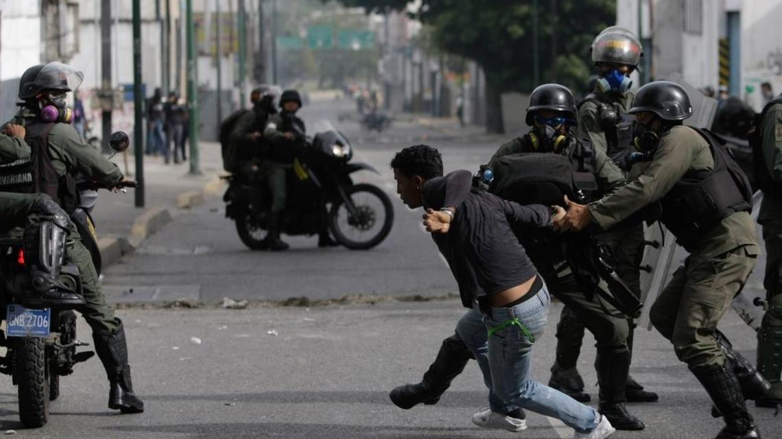 Un manifestante trata de huir de las fuerzas de seguridad durante una protesta contra el gobierno del presidente Nicolás Maduro, este lunes en Caracas.