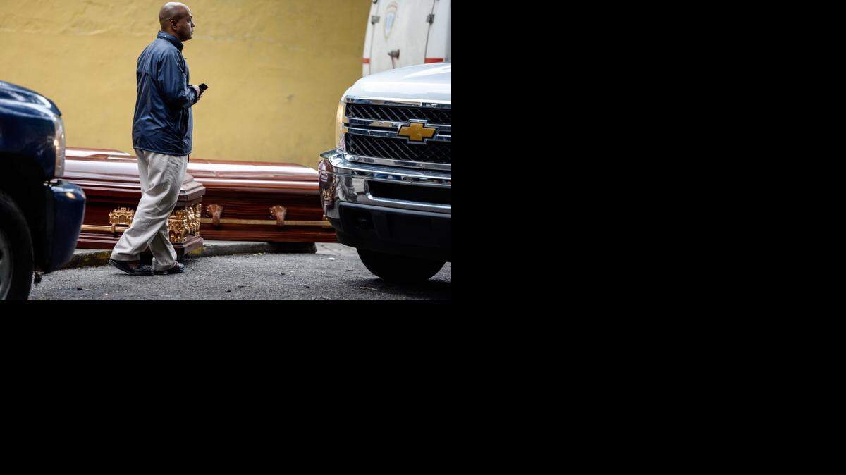 
Un hombre camina frente a varios en la morgue general de Caracas, el 10 de septiembre de 2014. El cuerpo de un hombre decapitado fue encontrado en un suburbio de Caracas, y horas más tarde la cabeza en otra zona de 30 kilómetros de distancia.
