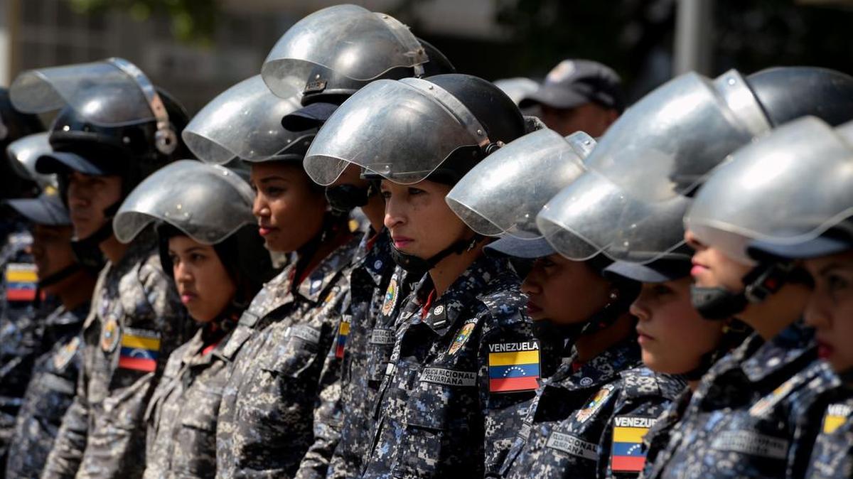 Members of the Bolivarian National Police (PNB) stand guard near “Dr. JM de los Rios” Children’s Hospital in Caracas, during a protest against the government of Nicolás Maduro.