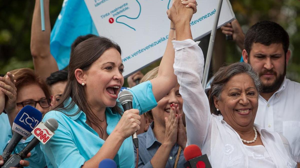 
La ex diputada venezolana de la Asamblea Nacional (AN) María Corina Machado (i), junto a la candidata Isabel Pereira (d), asiste a la sede de la Junta Electoral Principal para intentar inscribir su candidatura para las elecciones parlamentarias de diciembre del presente año, el lunes 3 de agosto de 2015, en la ciudad de Los Teques (Venezuela).
