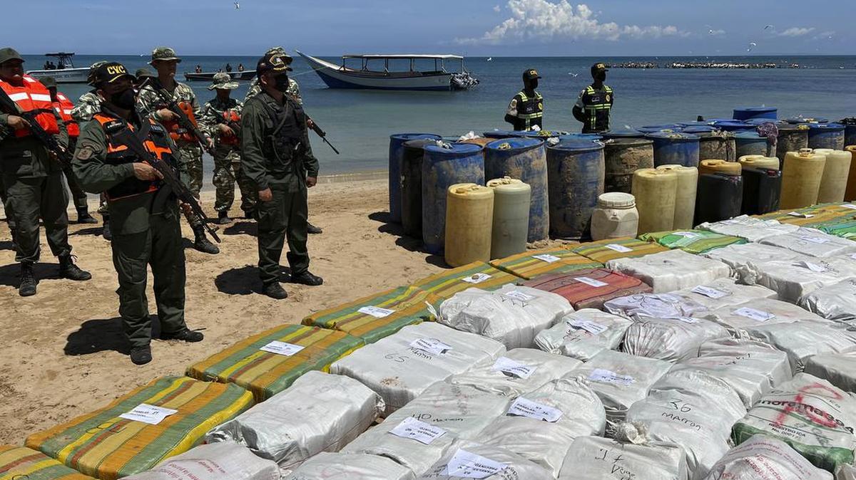 Sacos que contienen drogas ilegales y barriles de plástico que contienen combustible, incautados por las fuerzas armadas de Venezuela, se exhiben en un campamento junto a la playa en el pueblo de Tiraya, Venezuela, el 5 de septiembre del 2022.