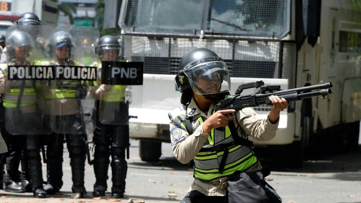 Una policía antimotín apunta su arma a un grupo de estudiantes de la Universidad Central de Venezuela, durante una protesta este jueves 9 de junio en Caracas.