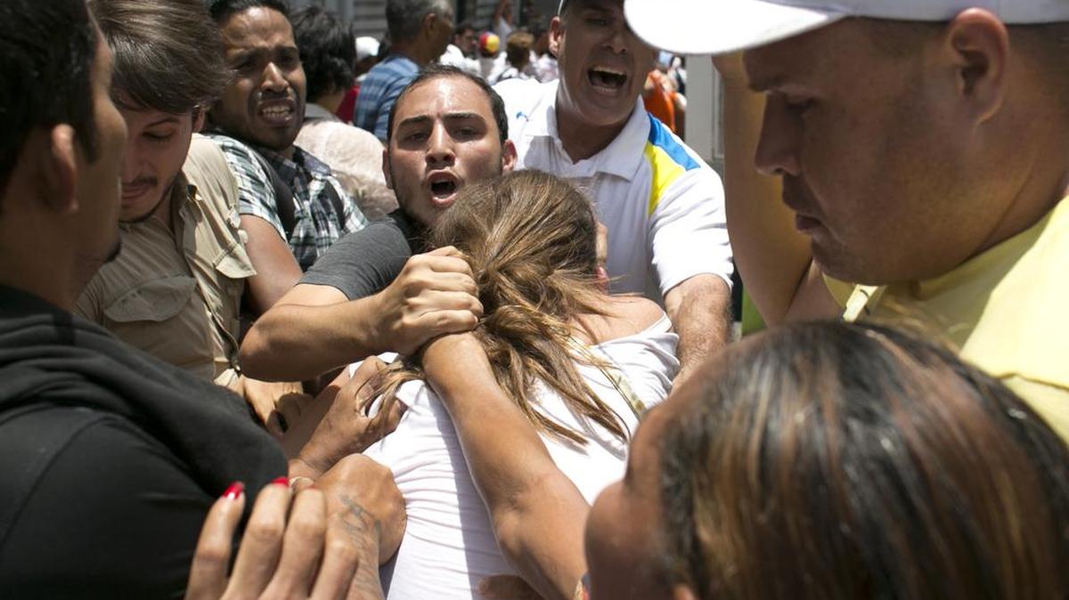 
Una partidaria del chavismo agrede a una muchar simpatizante del líder opositor Leopoldo López, el jueves en las afueras del Palacio de Justicia en Caracas. 
