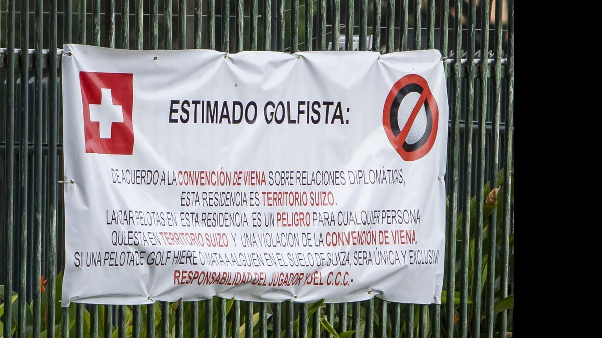 
Vista de una pancarta en los alrededores de la embajada suiza hoy, miércoles 17 de junio del 2015, en la ciudad de Caracas (Venezuela). La Federación Venezolana de Golf (FVG) reclama el hoyo 3 del campo de golf del Caracas Country Club (CCC), colindante con la residencia de la embajadora de Suiza en ese país, Sabine Ulmann. La pancarta puesta en ese sector subraya que "lanzar pelotas" allí significa un "peligro" en "territorio suizo".
