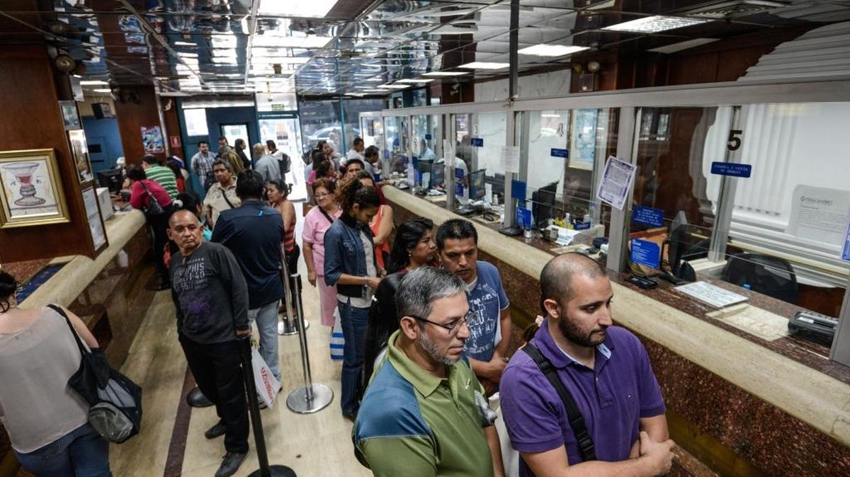 Un grupo de personas espera en una oficina de cambios en Caracas, en febrero. Maduro no ha hecho los cambios necesarios para evitar inflación y devaluación porque teme una respuesta negativa antes de las elecciones.