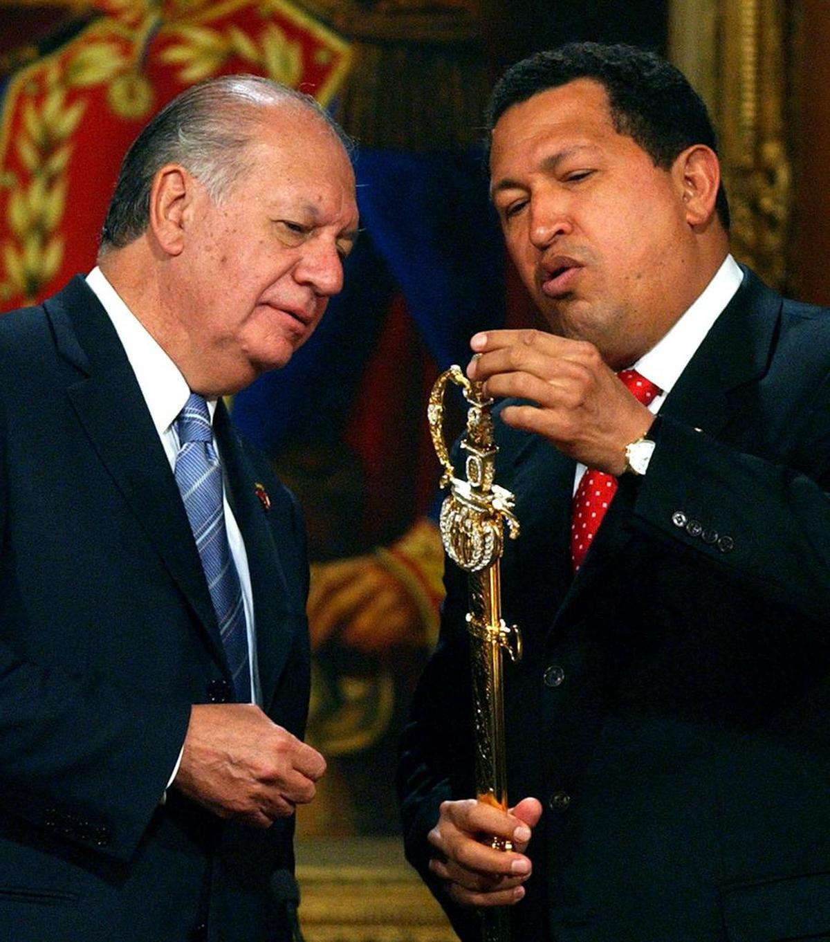 El ex presidente chileno, Ricardo Lagos (izda), recibe de su homólogo venezolano, Hugo Chávez (dcha), una réplica de la espada del Libertador Simón Bolivar, el miércoles 20 de abril, en el Palacio de Miraflores en Caracas (Venezuela).