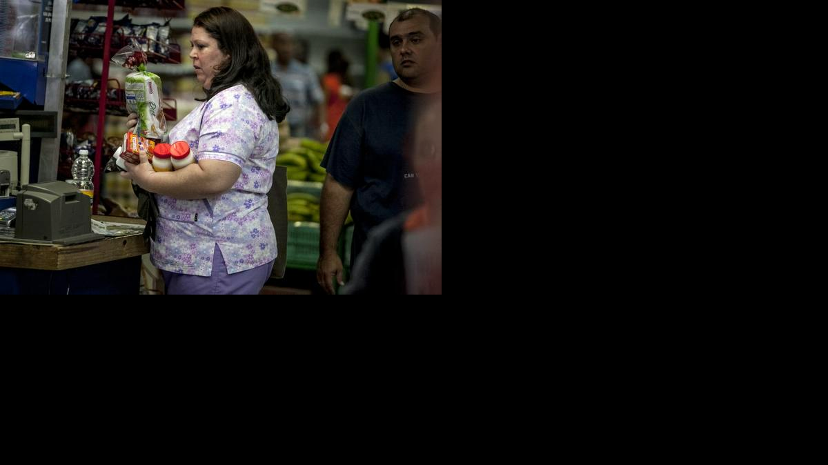 
Una mujer carga en sus manos alimentos dentro de un supermercado privado el viernes 9 de enero del 2015, en la ciudad de Caracas (Venezuela).
