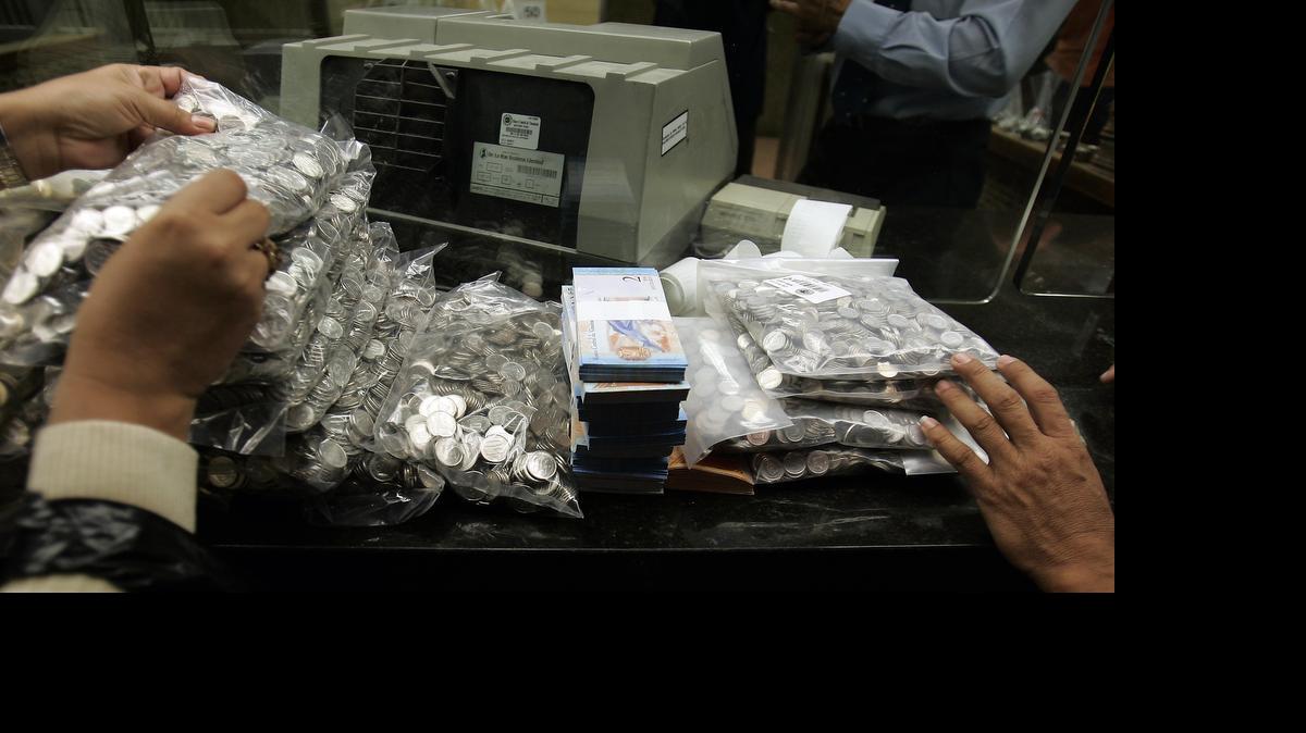 
Imagen de enero de 2008 que muestra a empleados contando “bolívares fuertes” en el Banco Central, en Caracas. Desde que Nicolás Maduro llegó al poder en Venezuela, el valor de la moneda se ha desplomado. 
