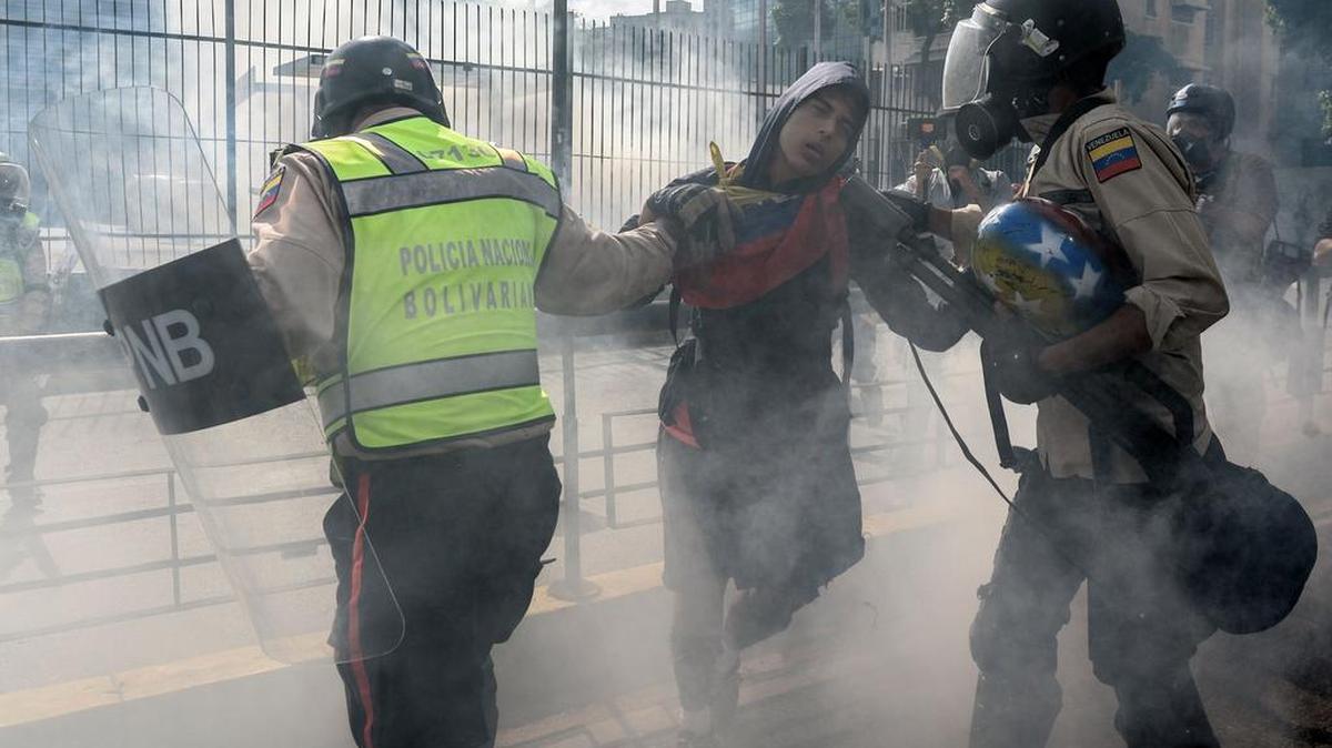 Policías arremeten contra un manifestante durante una protesta contra el gobierno del presidente Nicolás Maduro en Caracas el 20 de mayo de 2017.