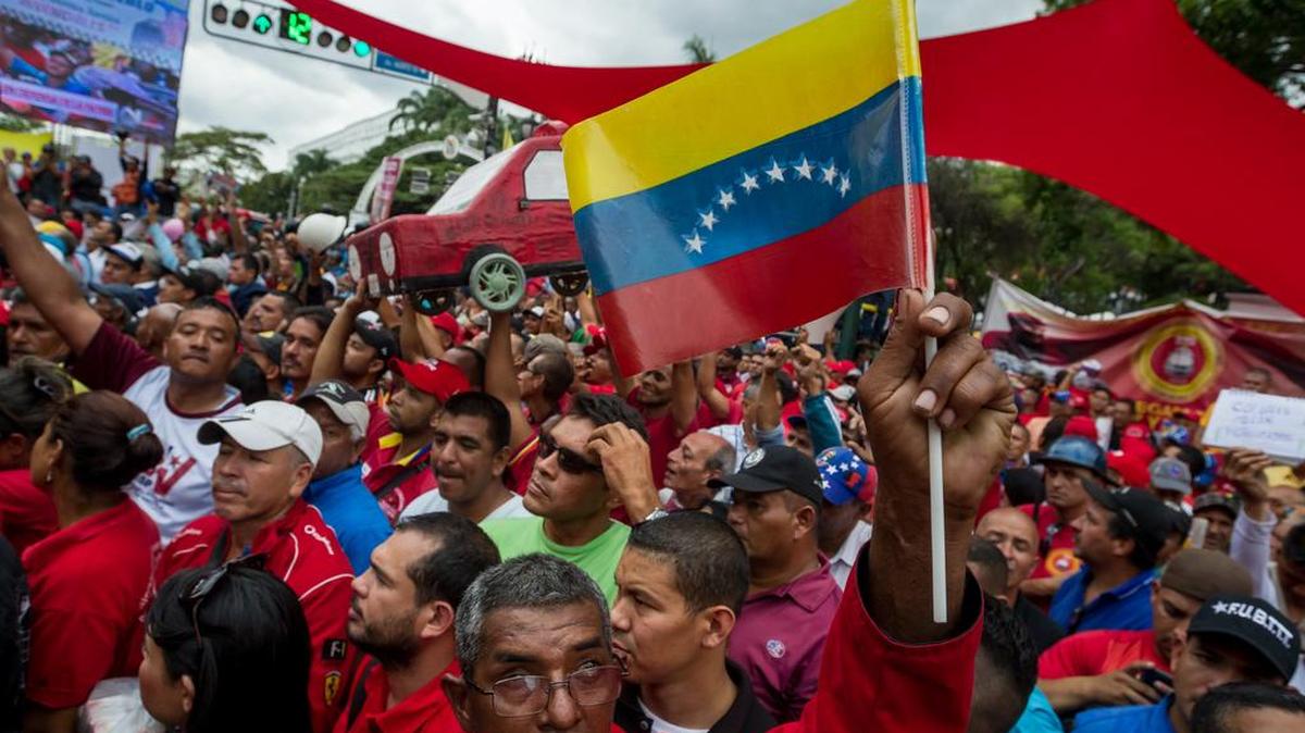 Un grupo de personas entre funcionarios públicos y seguidores del chavismo marchan el martes, en apoyo al presidente venezolano Nicolás Maduro en Caracas.