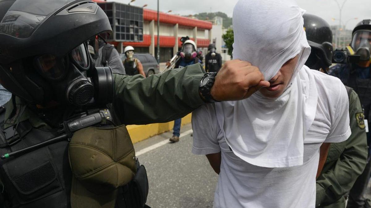 Un manifestante de la oposición es detenido por un policía el lunes 22 de mayo de 2017, en Caracas, Venezuela.