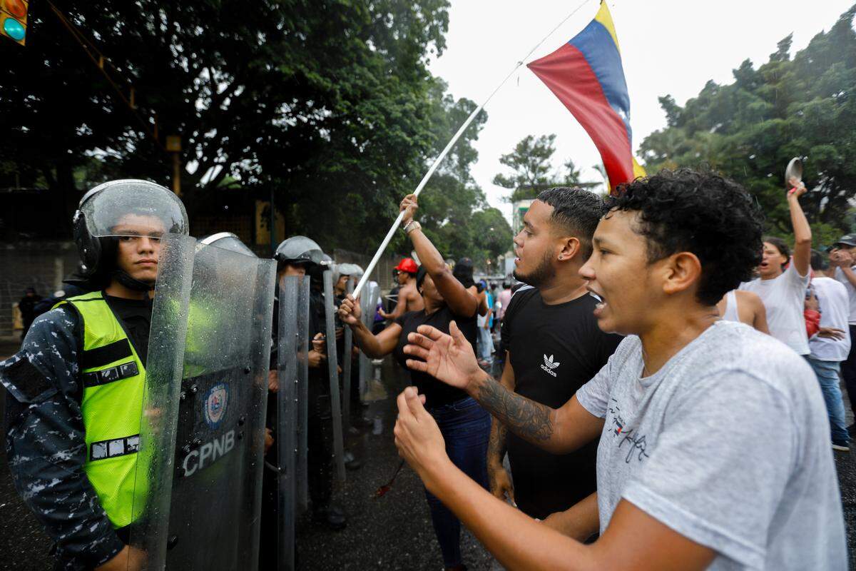 Manifestantes expresan su ira frente a una fila de policías durante una protesta contra los resultados oficiales de las elecciones presidenciales. 29 de julio de 2024, Venezuela, Caracas. 