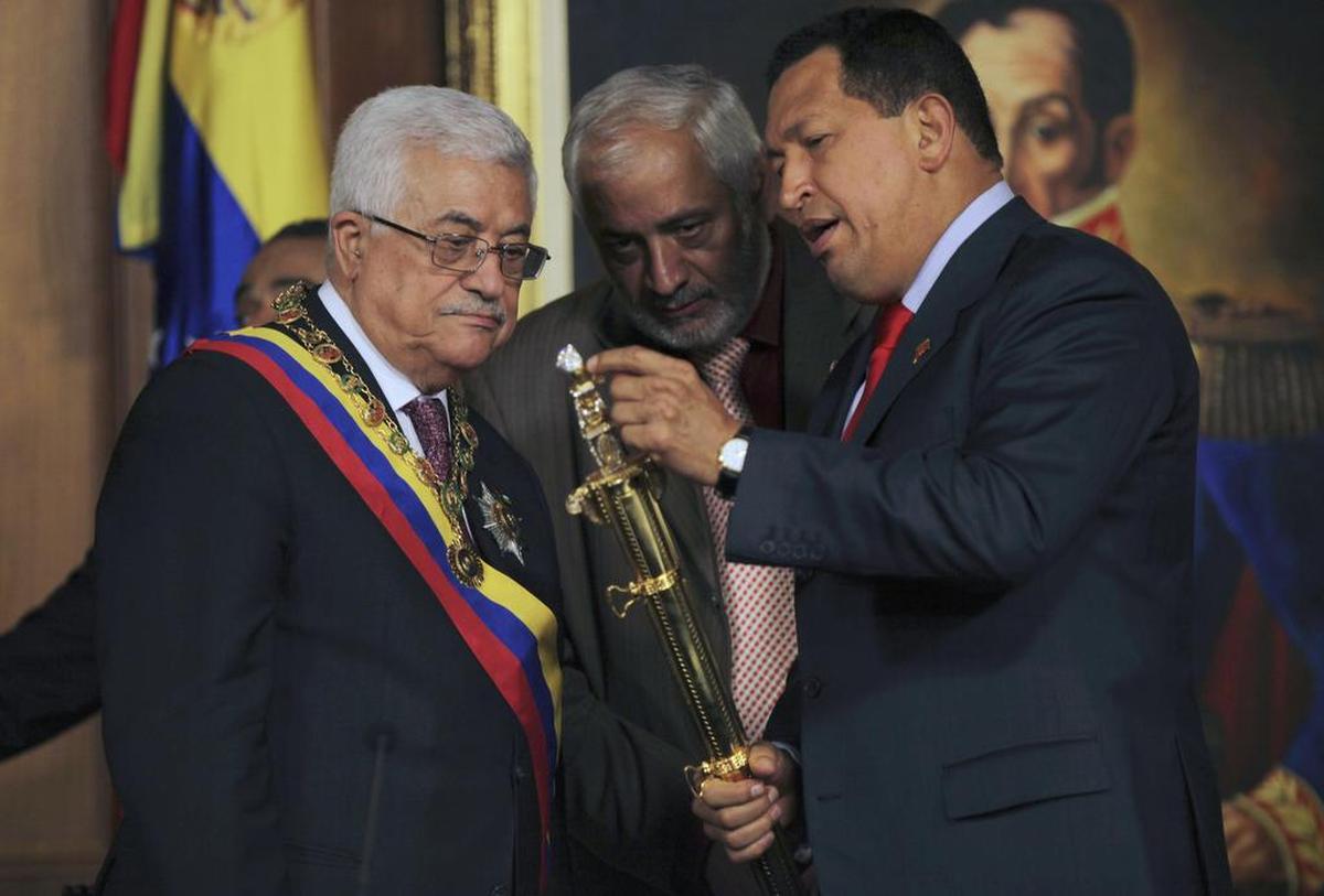 El presidente palestino, Mahmud Abbas, a la izquierda, observa una réplica de la espada de Simón Bolívar, heredero de la independencia venezolana, al recibirla del ex presidente venezolano Hugo Chávez en el palacio presidencial de Miraflores, en Caracas, viernes 27 de noviembre de 2009.