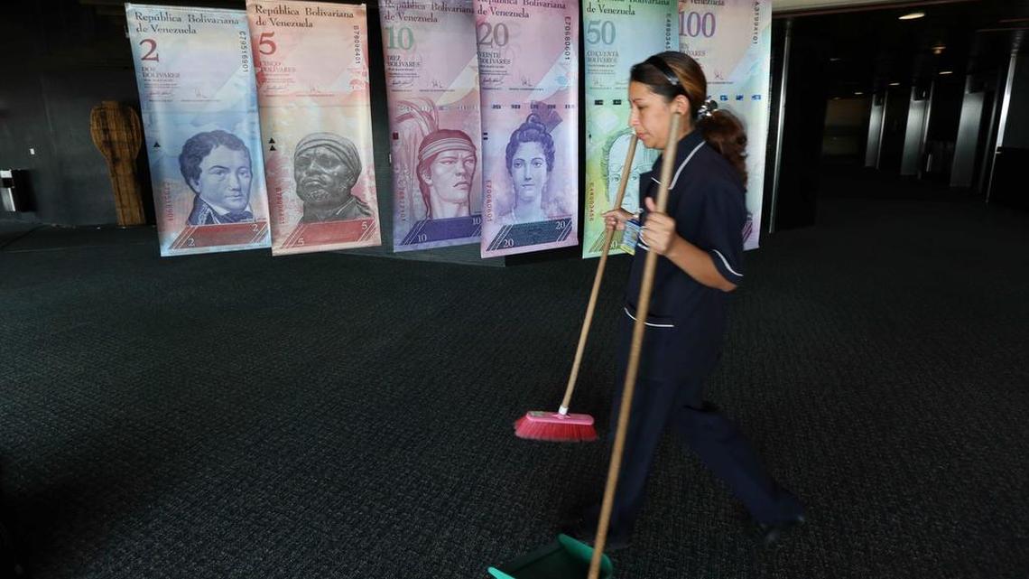 Una mujer camina junto a las réplicas de billetes de bolívares, la moneda venezolana, en un pasillo del Banco Central de Venezuela.