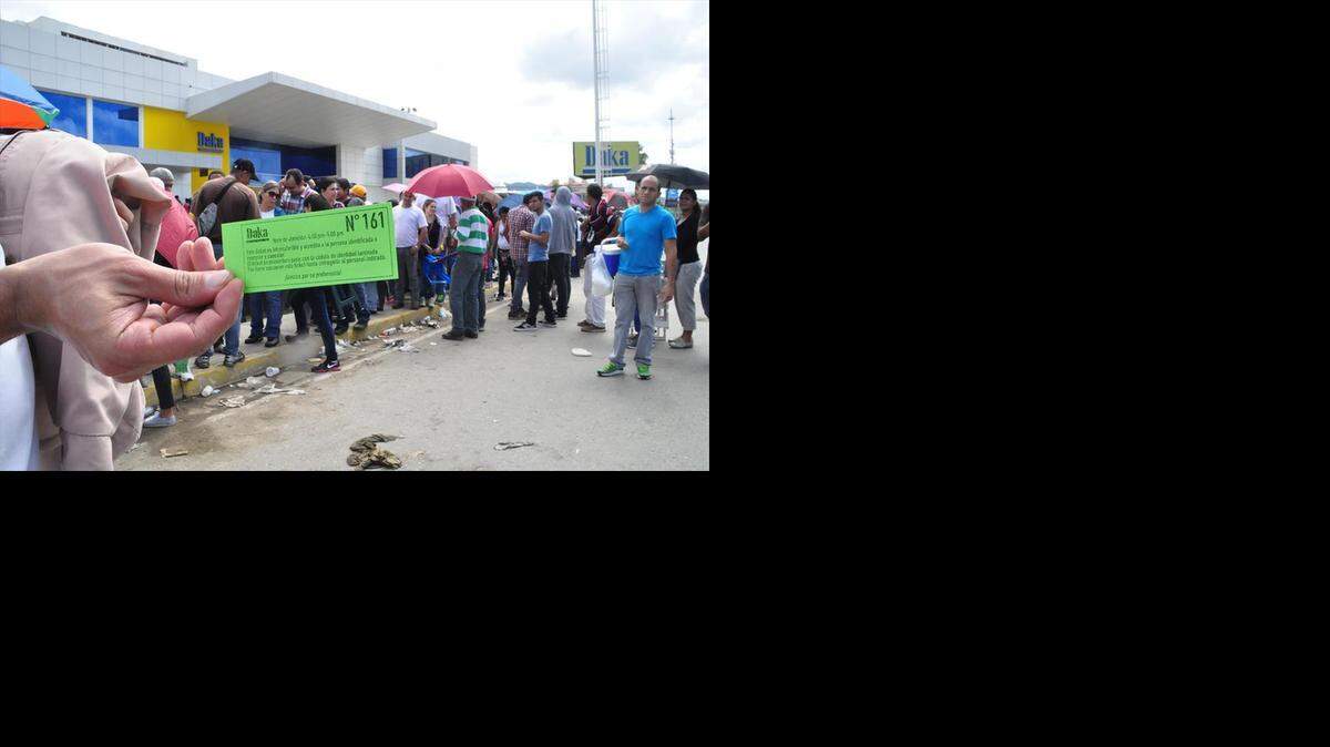 
Venezolanos hacen fila en una cadena de electrodomésticos, en la ciudad de Valencia, para adquirir aparatos importados con dólares a precio preferencial.
